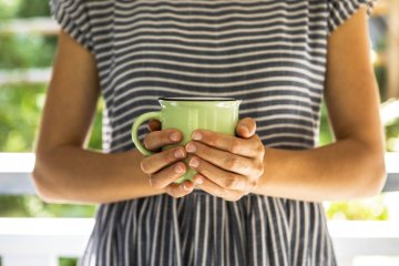 Frau, die eine Tasse hält